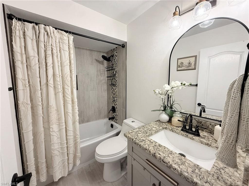 Full 2nd bathroom featuring shower / bath combo with shower curtain and vanity