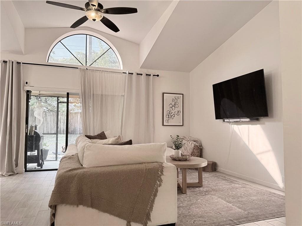Living room featuring access to outside, high vaulted ceiling, and ceiling fan