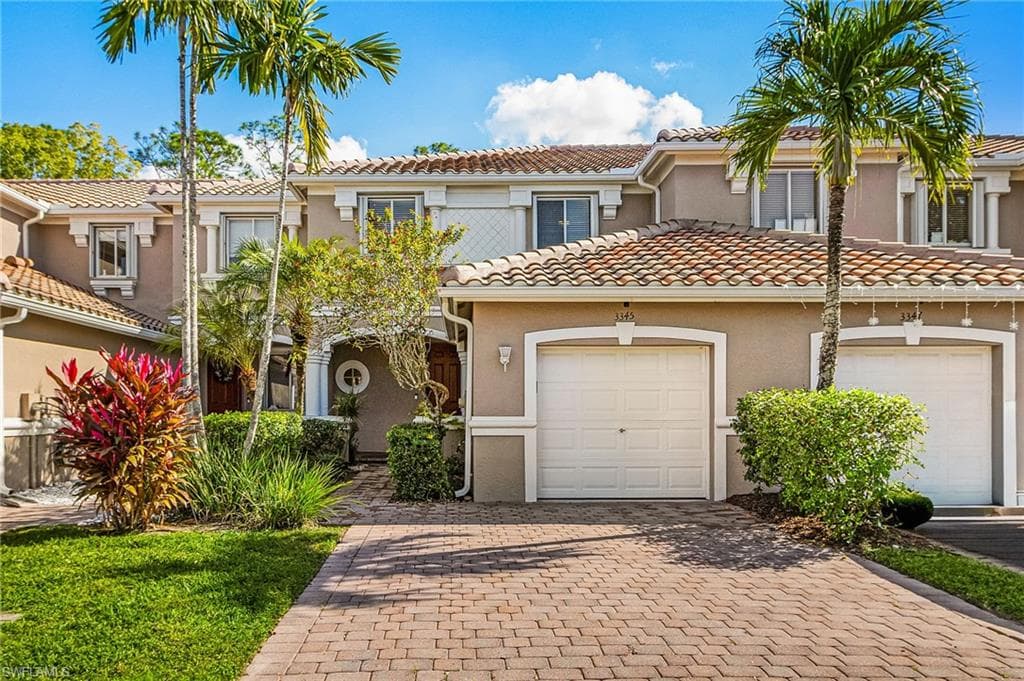 Mediterranean / spanish home featuring stucco siding, decorative driveway, a tile roof, and an attached garage