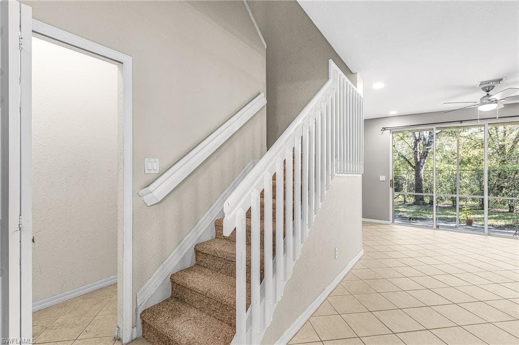 Staircase with tile patterned flooring, ceiling fan, and recessed lighting