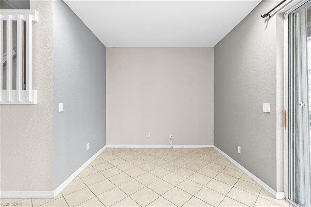 Spare room with a textured wall and light tile patterned floors