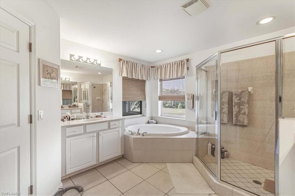 Bedroom with a raised ceiling, light colored carpet, ceiling fan, and recessed lighting