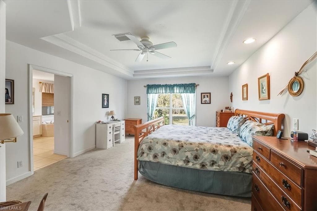 Bedroom with a closet, carpet floors, ceiling fan, and arched walkways