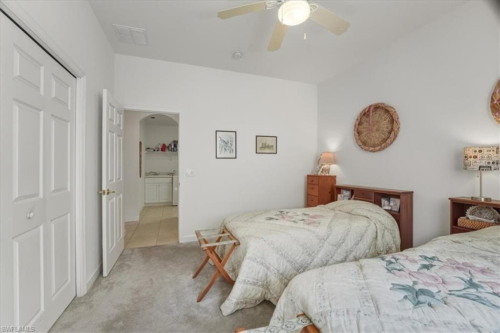 Carpeted living room with a ceiling fan