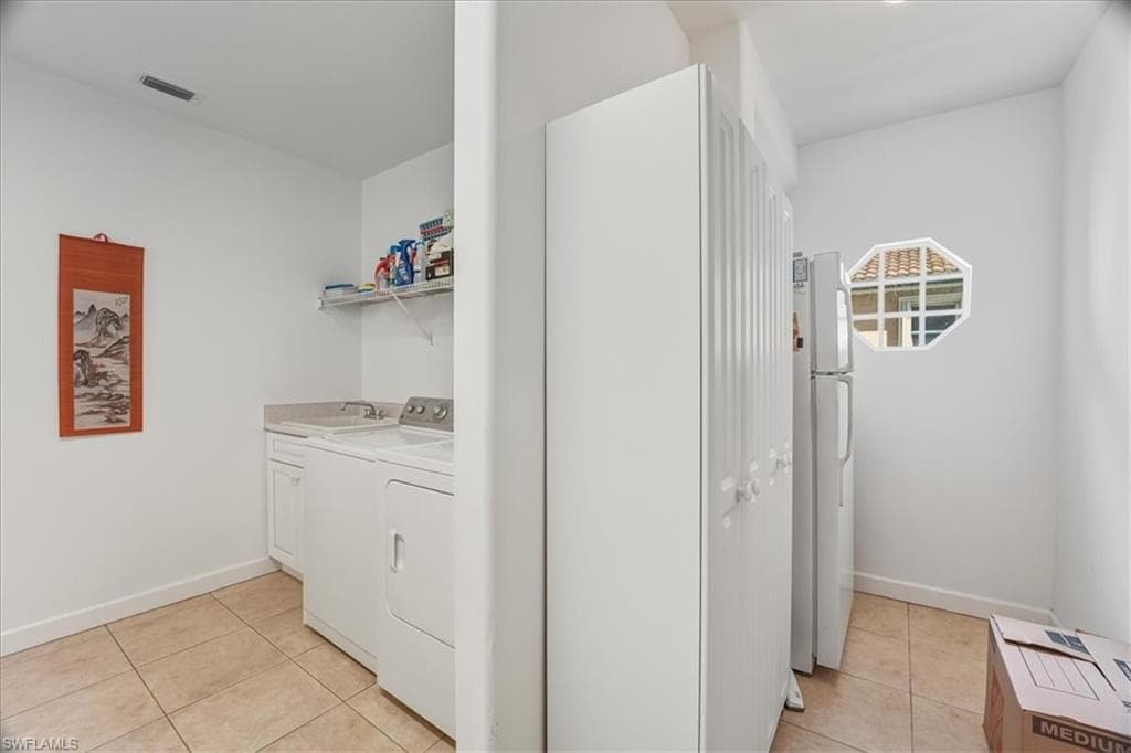 Full bathroom featuring double vanity, light tile patterned floors, and bath / shower combo with glass door