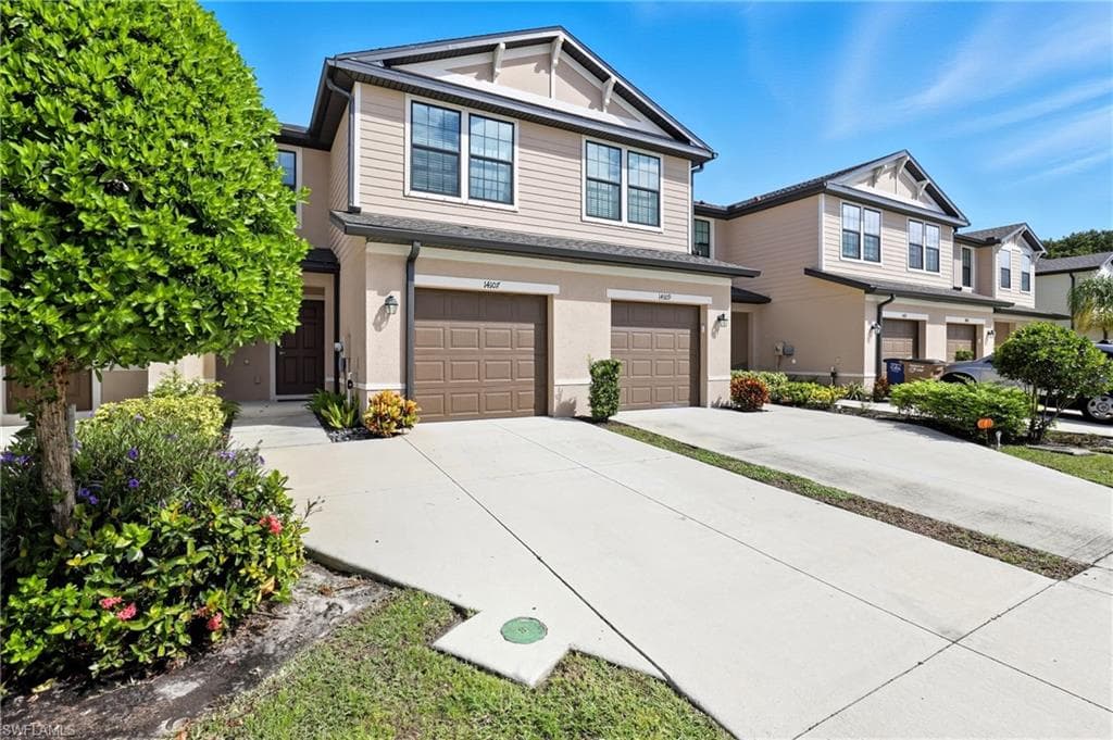 Craftsman house featuring driveway, a garage, and stucco siding