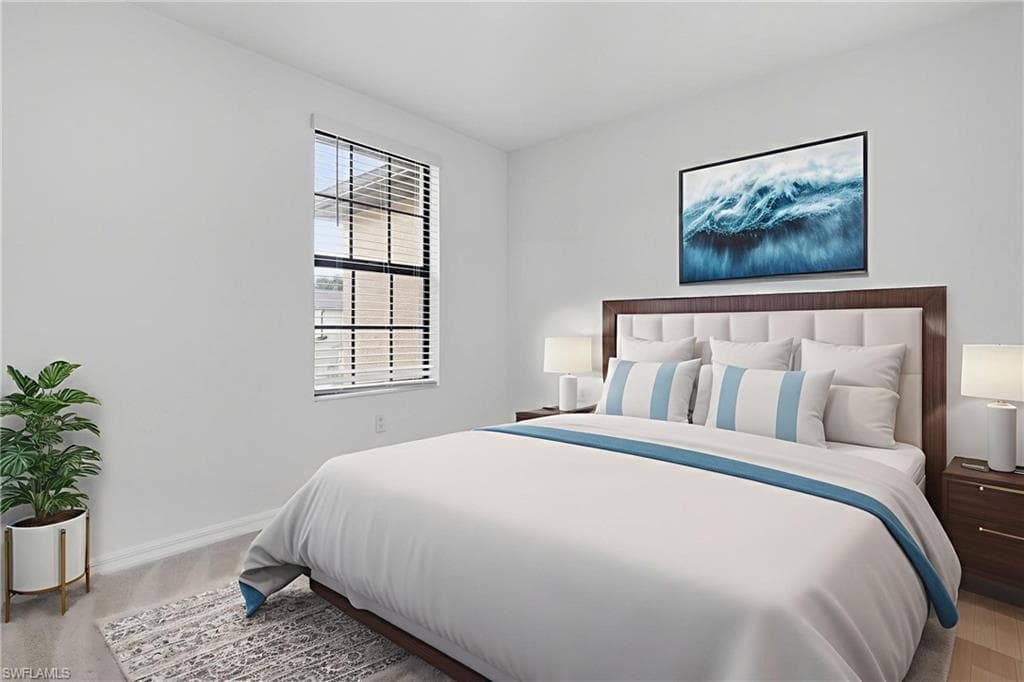 Bedroom featuring baseboards and light carpet