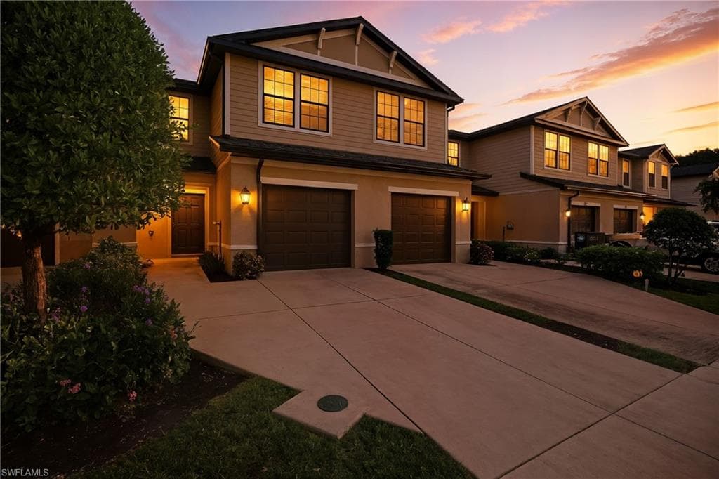 Craftsman-style house featuring concrete driveway, an attached garage, and stucco siding