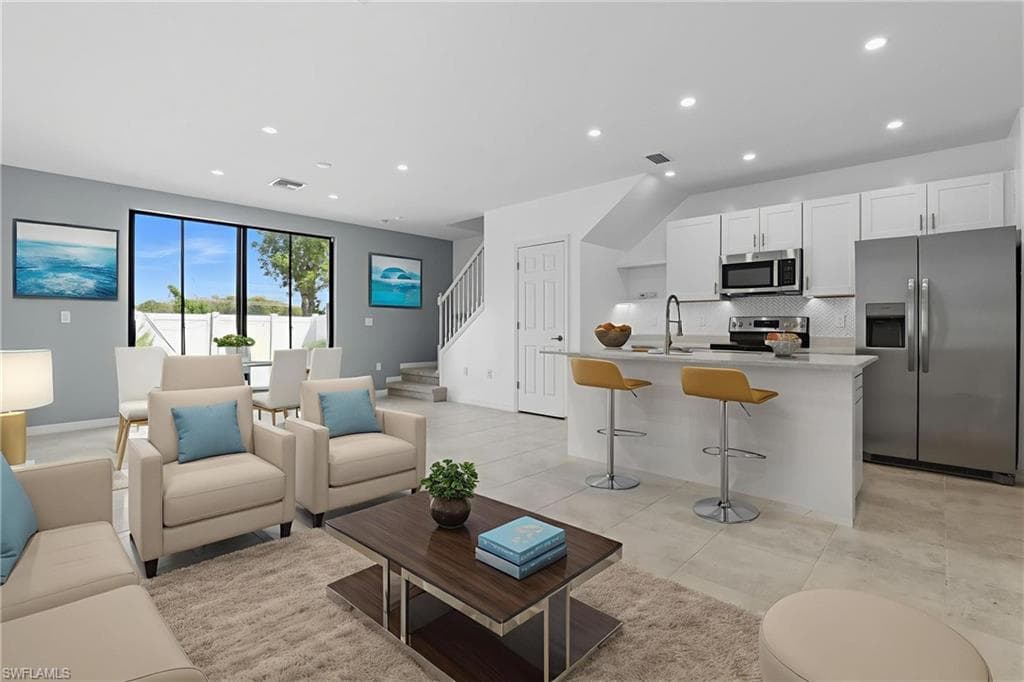 Living area with recessed lighting, stairway, and light tile patterned floors