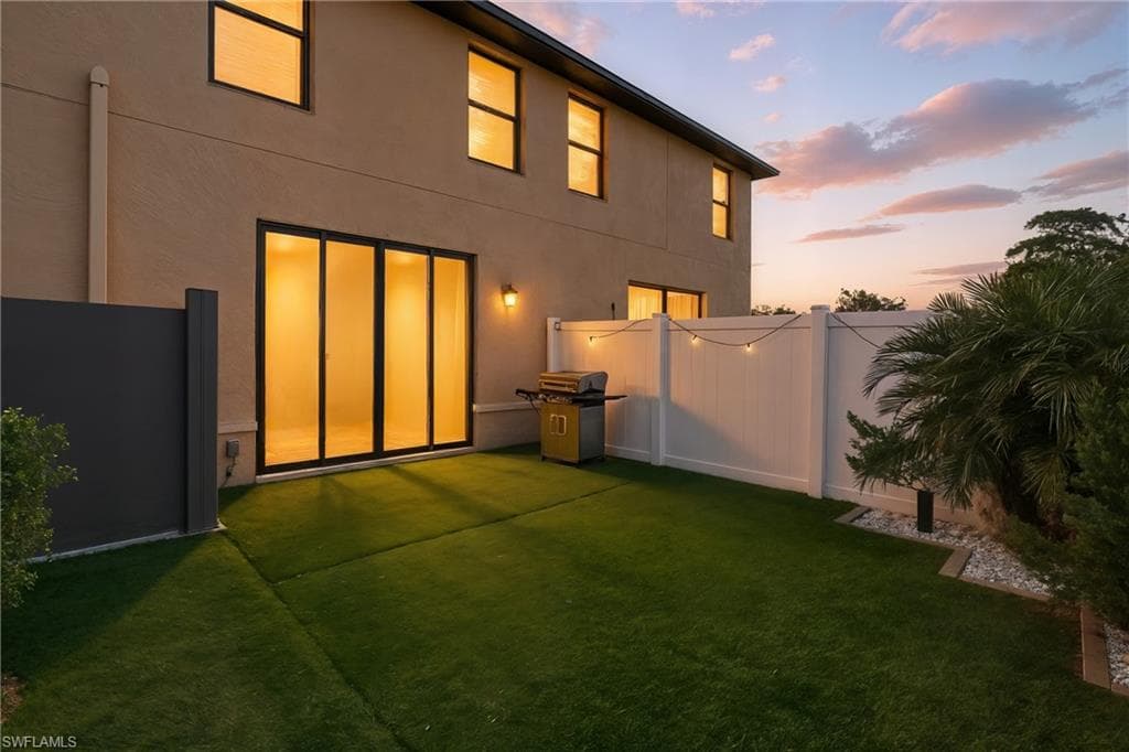 Back of house at dusk featuring stucco siding
