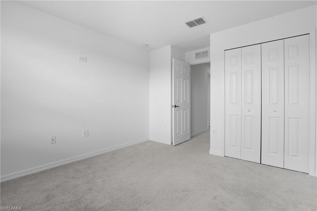 Unfurnished bedroom with carpet flooring and a closet
