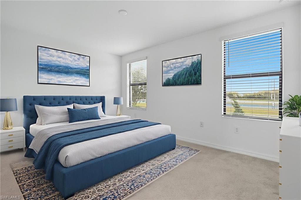 Bedroom featuring light carpet and baseboards