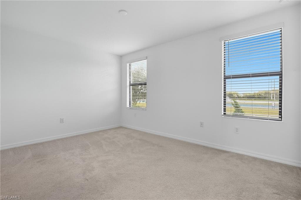 Unfurnished room featuring light carpet
