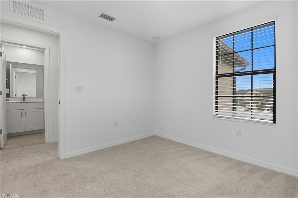 Unfurnished room with light carpet and baseboards