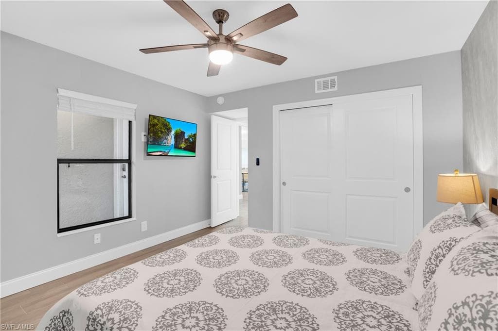 Bedroom featuring light wood-type flooring, ceiling fan, and a closet