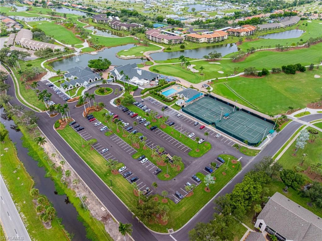 Aerial perspective of suburban area featuring a large body of water and a golf club