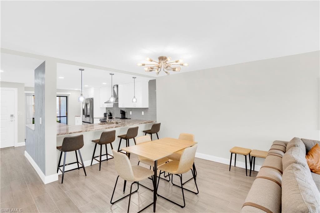Dining space with wood tiled floors, a chandelier, and recessed lighting