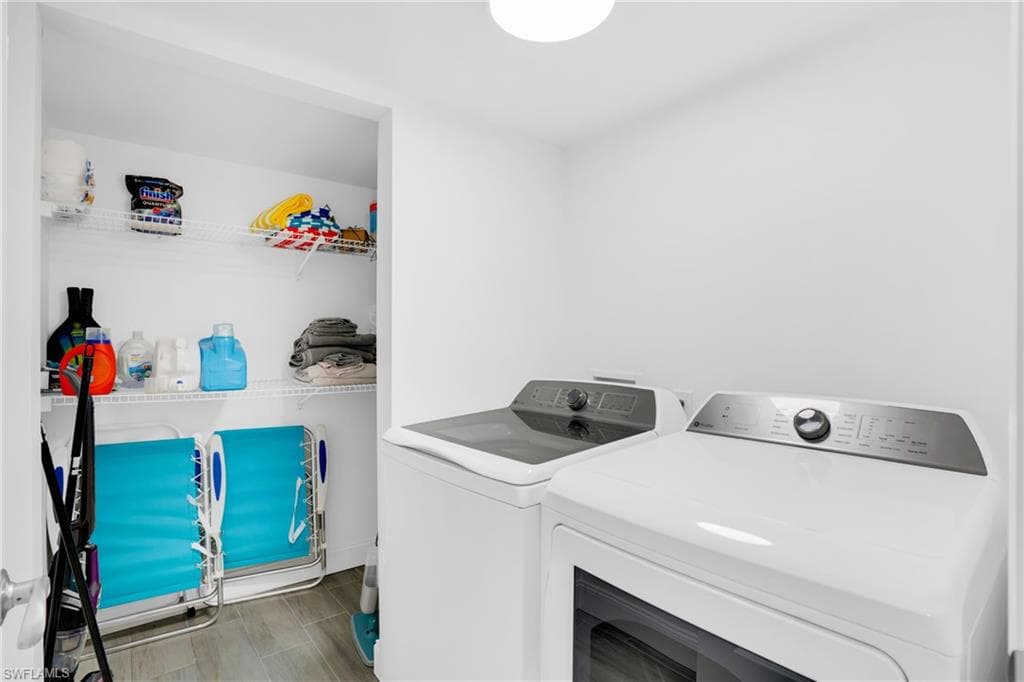 Laundry area with washing machine and dryer and wood tiled floors