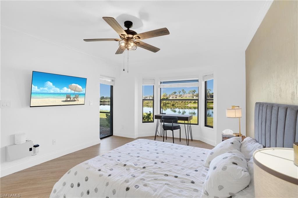 Bedroom with access to exterior, wood finished floors, and a ceiling fan