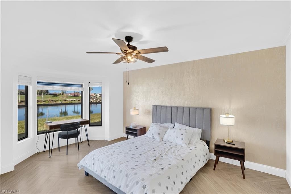 Bedroom with a water view and a ceiling fan