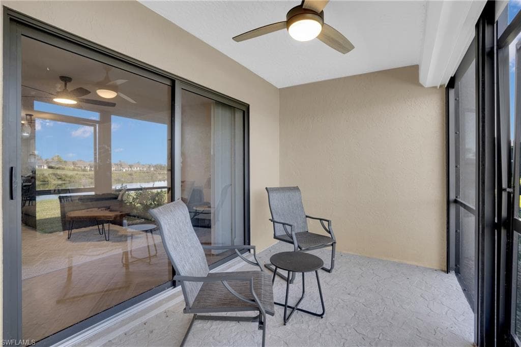 Sunroom featuring a ceiling fan and a balcony