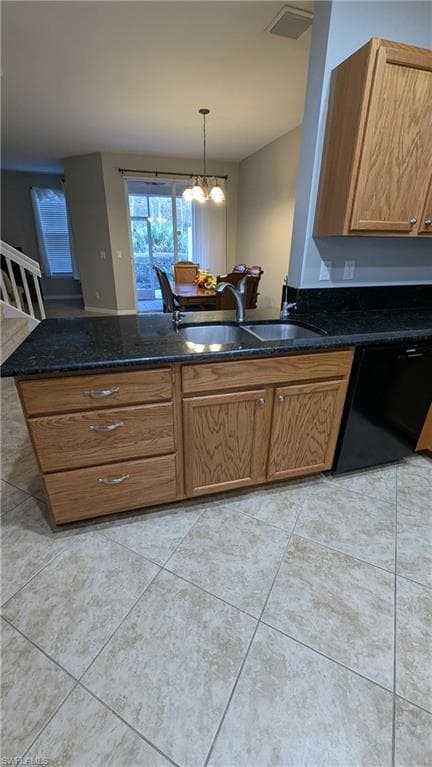 Kitchen with brown cabinetry, dishwasher, pendant lighting, a peninsula, and dark stone counters