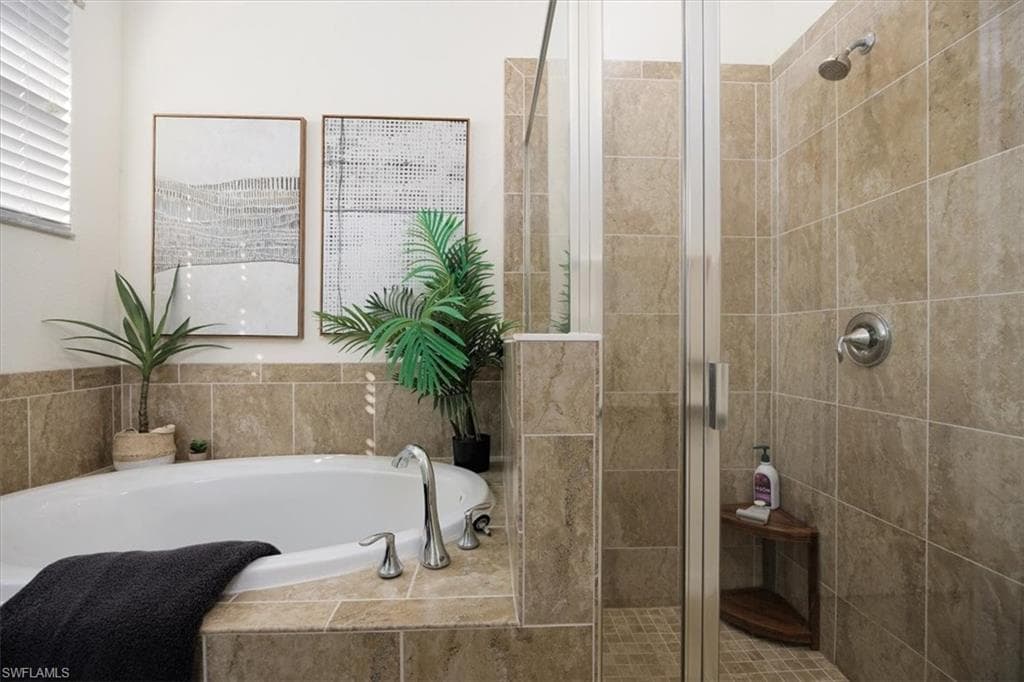 Bathroom featuring a garden tub and a shower stall