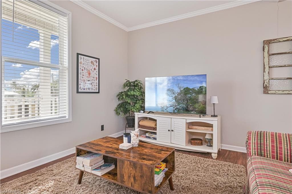 Living room featuring crown molding and dark wood finished floors