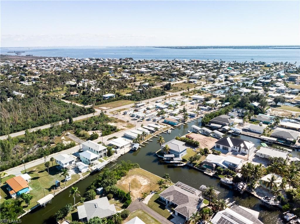 Aerial view of property's location with a large body of water and nearby suburban area