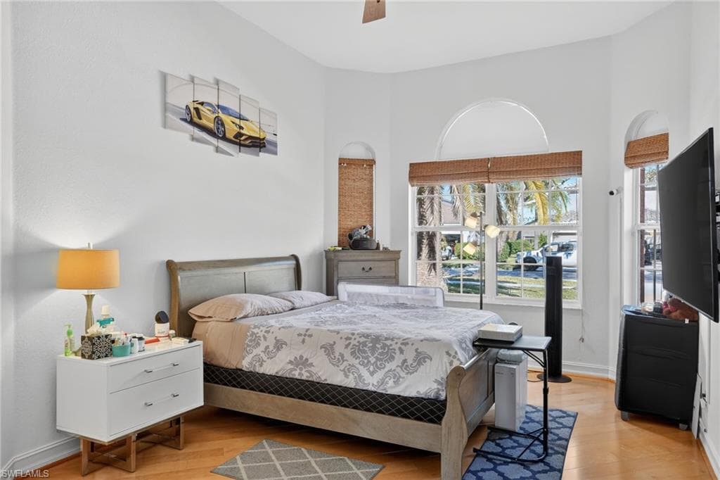 Bedroom with ceiling fan and light wood-style flooring