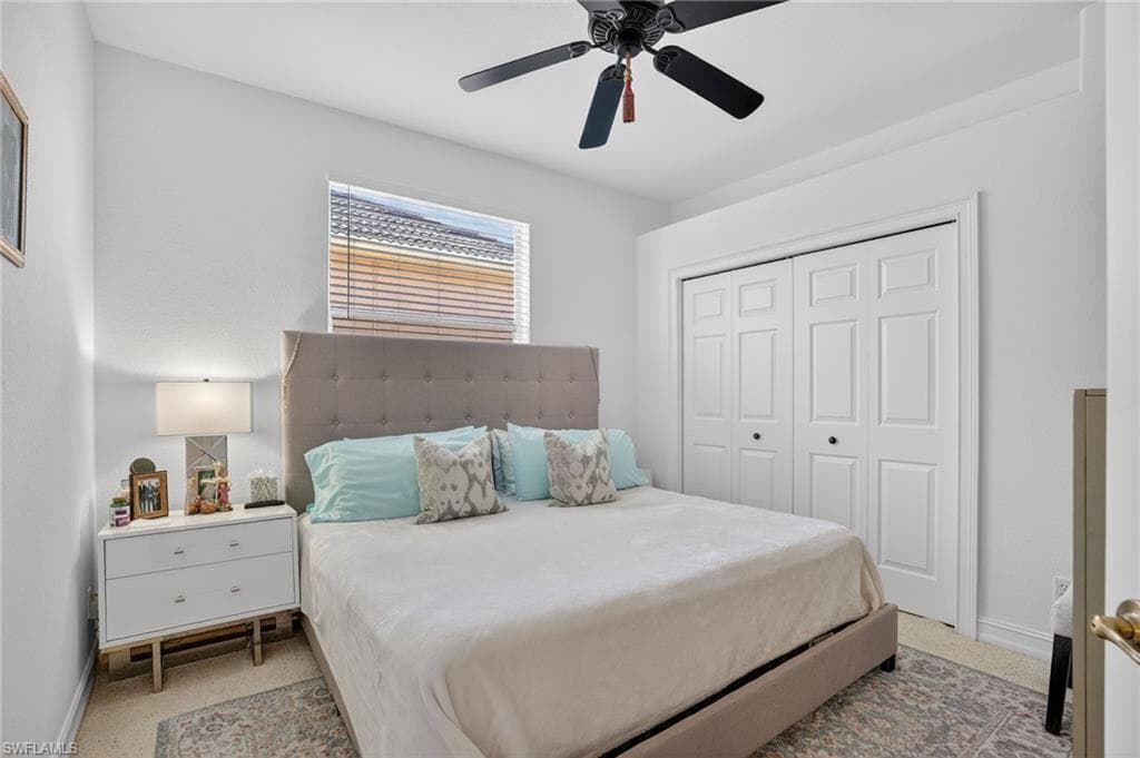 Bedroom featuring ceiling fan, a closet, and light carpet