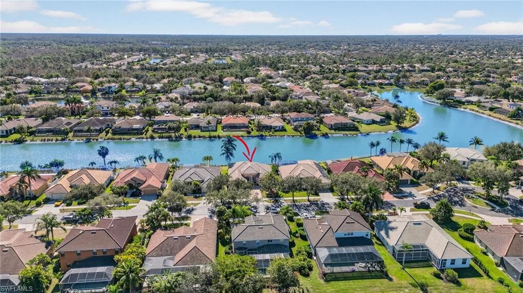 Aerial view of residential area featuring a nearby body of water