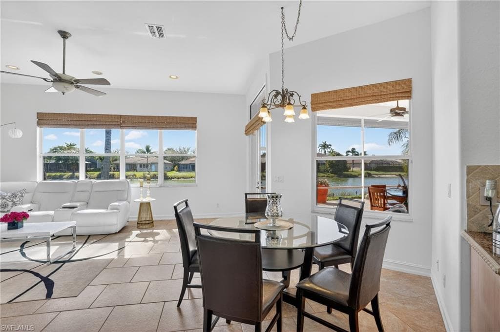 Dining room with a ceiling fan, plenty of natural light, recessed lighting, light tile patterned floors, and a chandelier