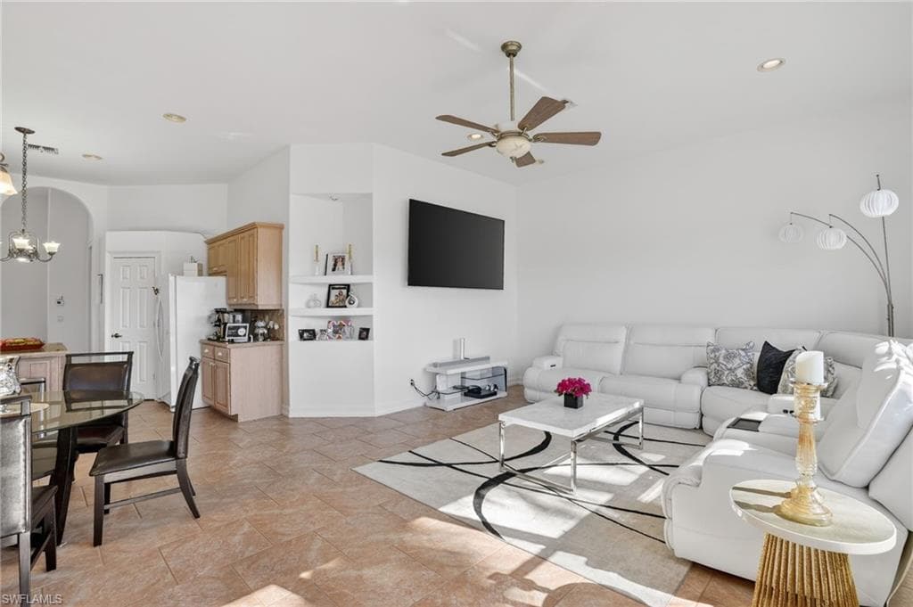 Living area with a chandelier, built in shelves, recessed lighting, and ceiling fan