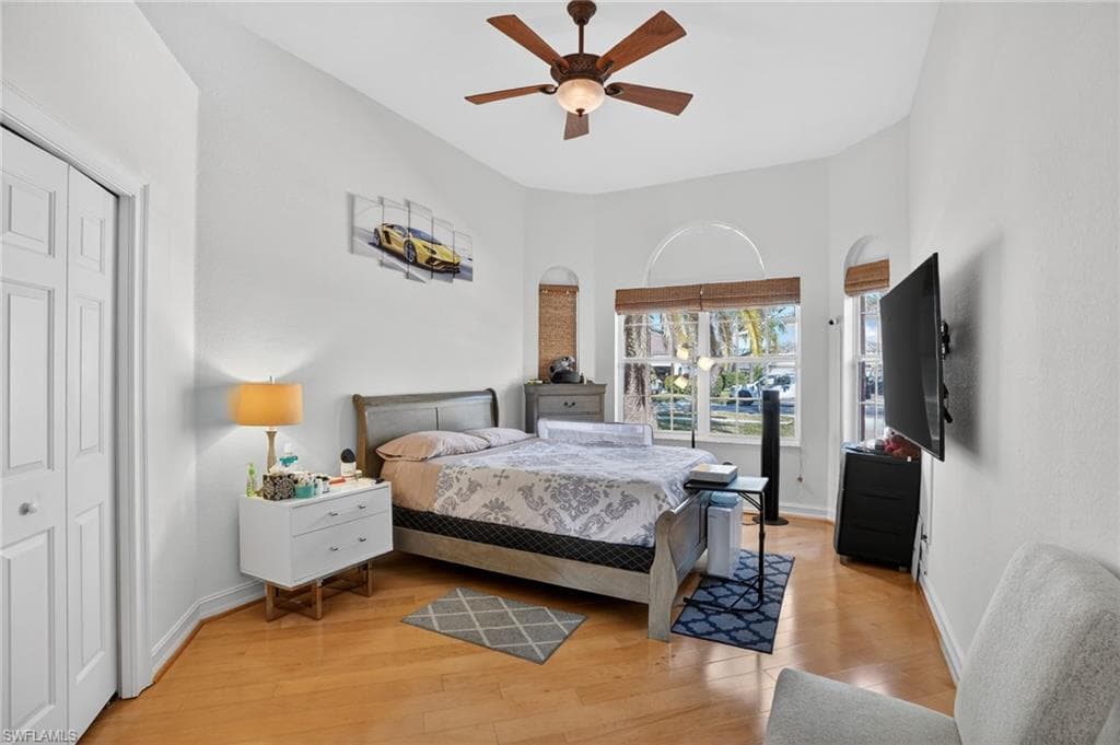 Bedroom with a ceiling fan, light wood finished floors, and a closet