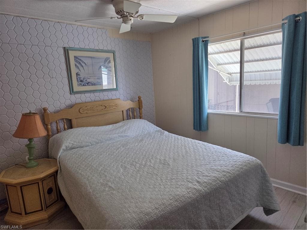 Guest Bedroom with ceiling fan and new flooring.
