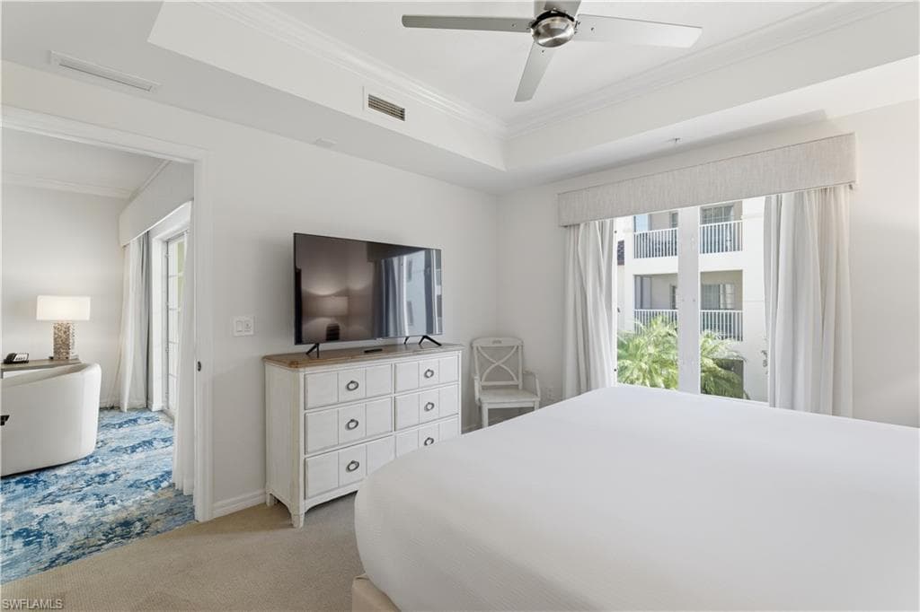 Bedroom featuring light carpet, ornamental molding, access to outside, ceiling fan, and a raised ceiling