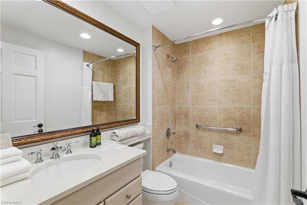 Full bathroom featuring vanity, shower / bath combo with shower curtain, and recessed lighting