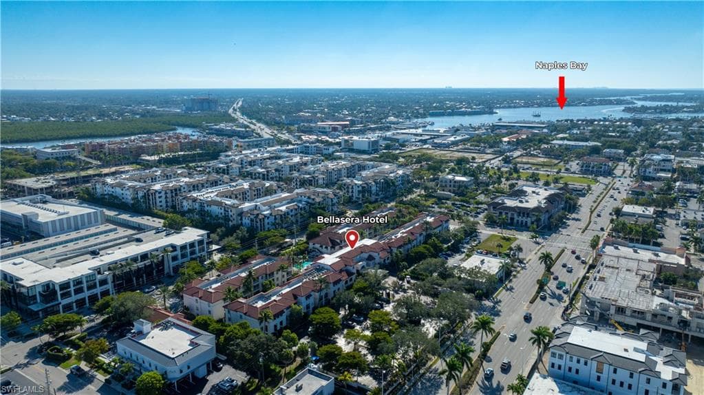 Aerial view of property and surrounding area with nearby urban area and a large body of water
