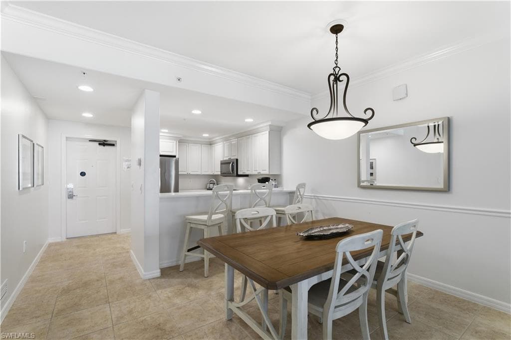 Dining space featuring recessed lighting, crown molding, and light tile patterned flooring