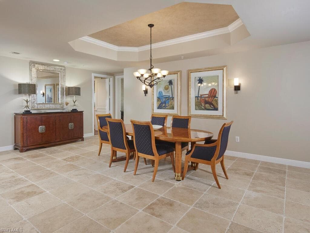Dining space featuring ornamental molding, light tile patterned floors, and a chandelier