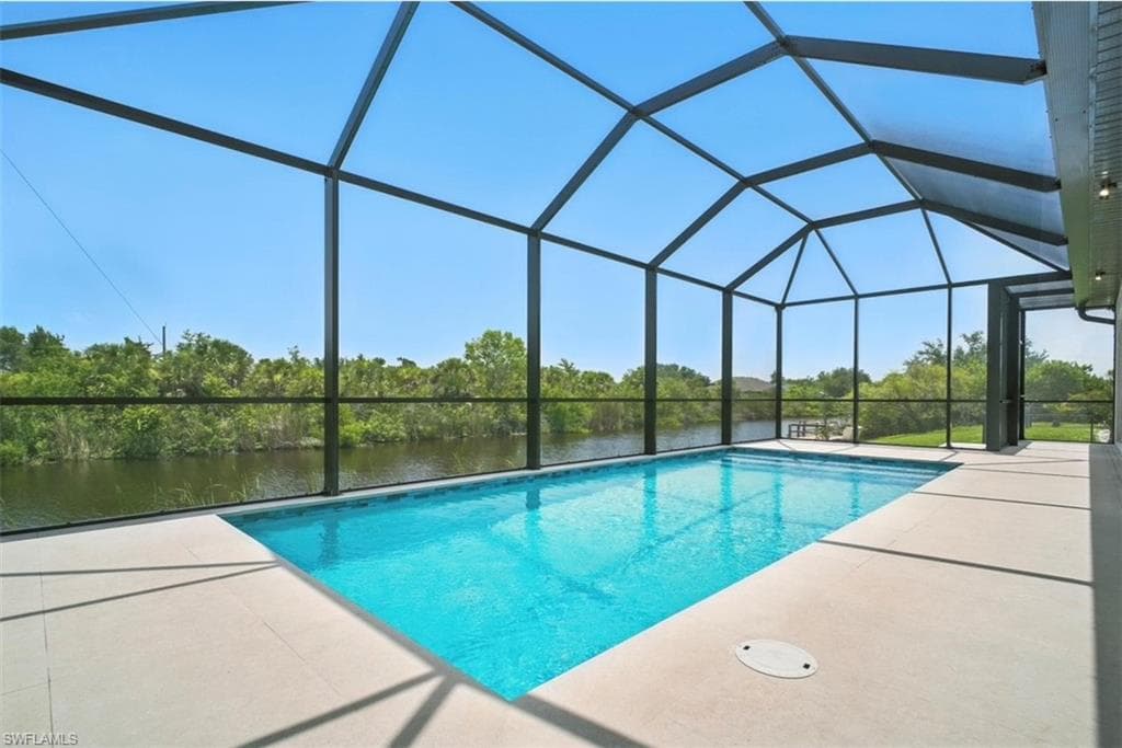 Outdoor pool with a sunroom, a lanai, a water view, and a patio area