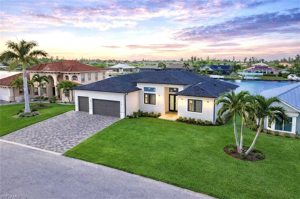 View of front of home with a lawn, decorative driveway, stucco siding, an attached garage, and roof with shingles (Rendered photo)