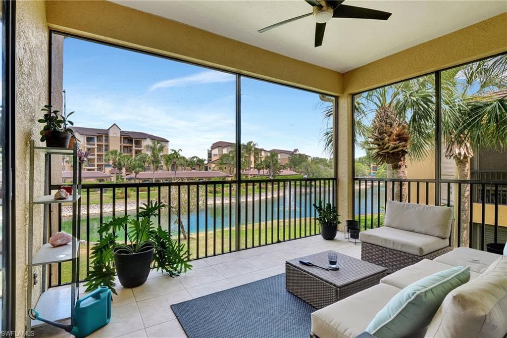 Sunroom / solarium with an outdoor living space, a ceiling fan, a water view, and a residential view