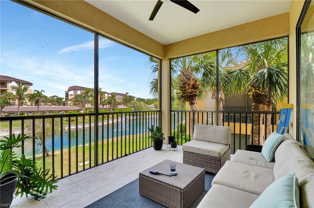 Sunroom with a ceiling fan, a water view, an outdoor hangout area, and a residential view