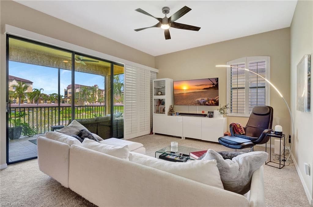 Living room with baseboards, ceiling fan, and carpet flooring
