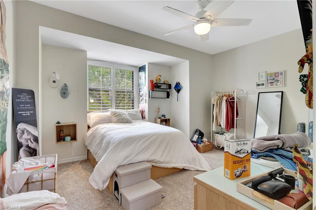 Bedroom with light colored carpet and a ceiling fan