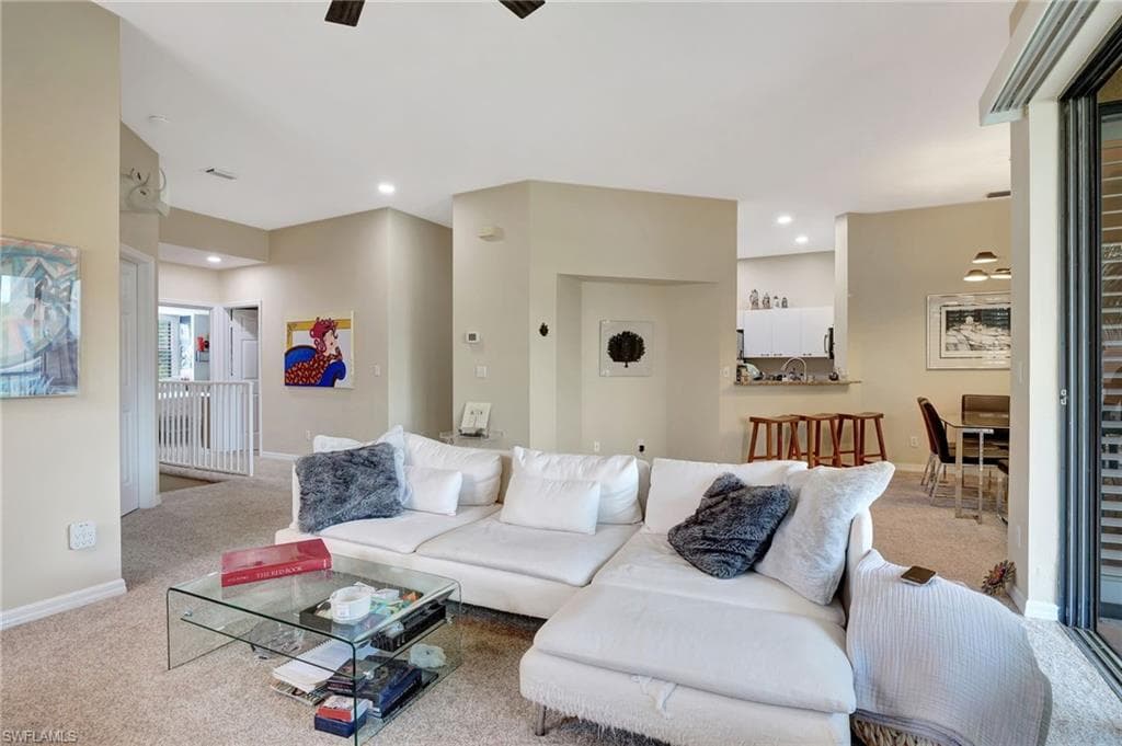 Living area featuring baseboards, recessed lighting, and carpet floors
