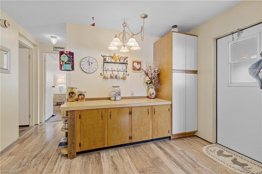 Kitchen with hanging light fixtures, light countertops, a chandelier