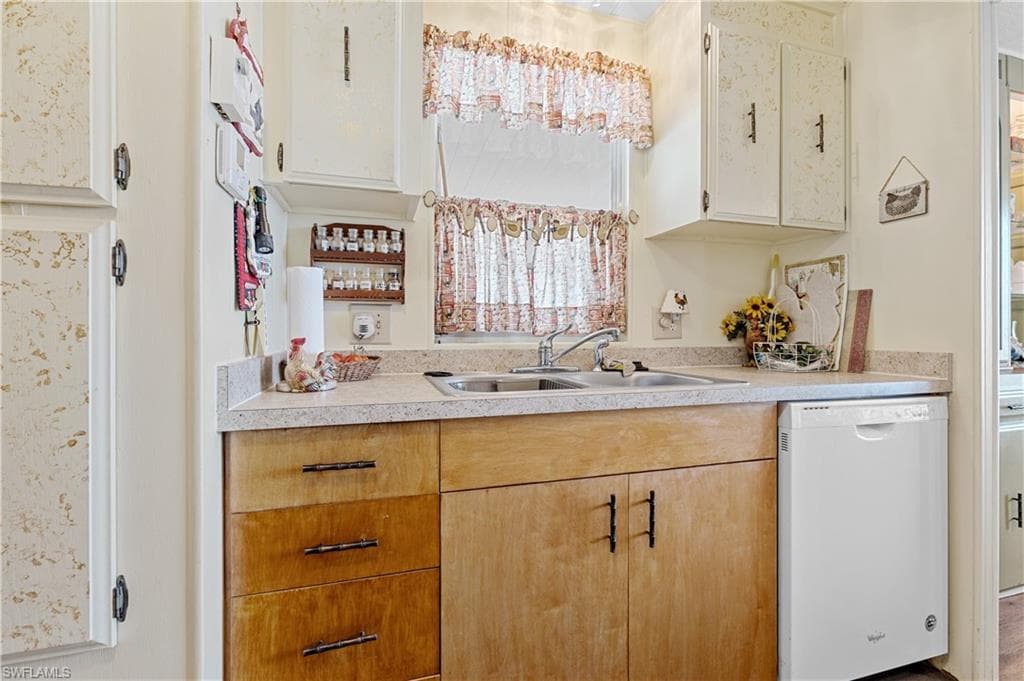 Kitchen with light countertops and white dishwasher